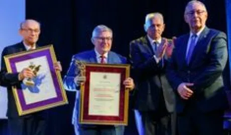 czterech mężczyzn stoją, dwoje z nagrodoami
